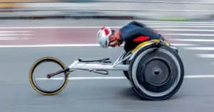 An amputee cyclist leaning forward to cycle to the finish line.