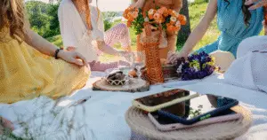young ladies, on a summer picnic, all their phones are placed to the side